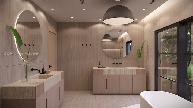 bathroom with a freestanding tub, two vanities, and tile walls