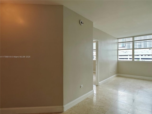 unfurnished room featuring baseboards