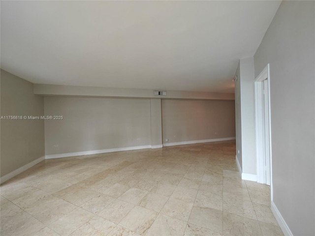 unfurnished room featuring baseboards and visible vents