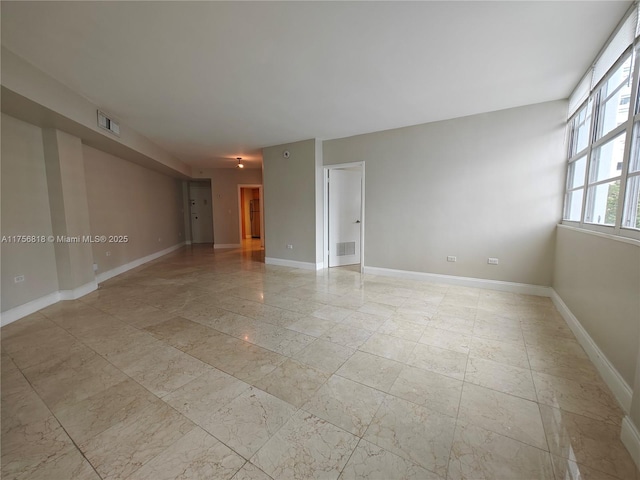 unfurnished room featuring visible vents and baseboards