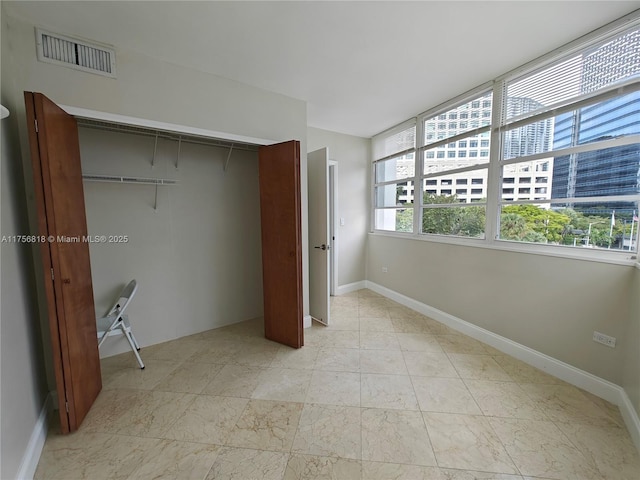 unfurnished bedroom featuring baseboards, visible vents, and a closet