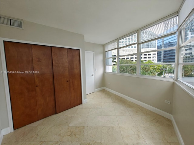 unfurnished bedroom featuring a closet, visible vents, and baseboards