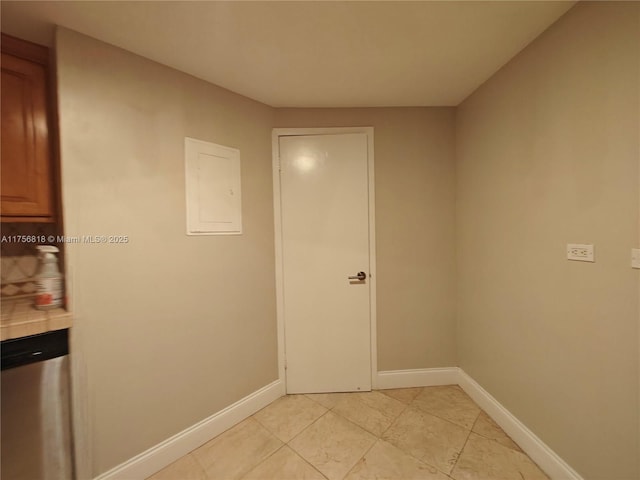 interior space with electric panel, baseboards, and light tile patterned floors