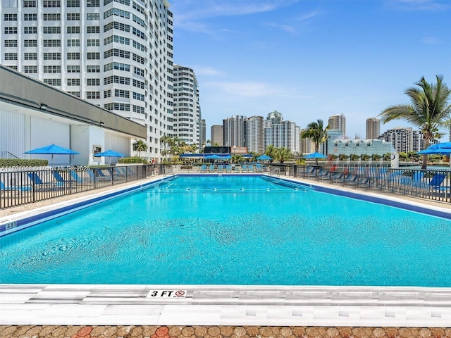 community pool featuring a city view and fence