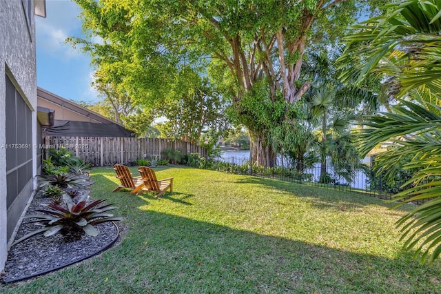 view of yard with a water view and a fenced backyard