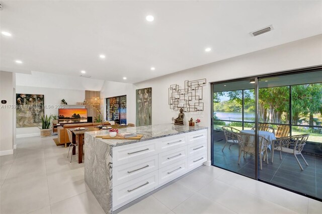 9705 SW 57th St, Cooper City, FL 33328 - kitchen featuring visible vents, white cabinets, a healthy amount of sunlight, and light stone countertops