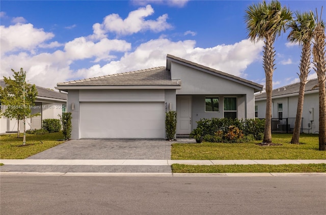 view of front of property featuring a front lawn, decorative driveway, an attached garage, and stucco siding