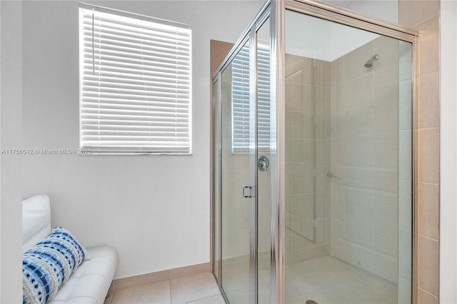 full bathroom with tile patterned flooring, plenty of natural light, and a shower stall