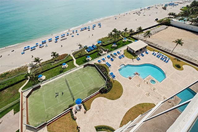 birds eye view of property with a water view and a beach view