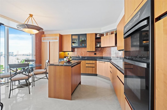 kitchen featuring dobule oven black, modern cabinets, backsplash, and a center island