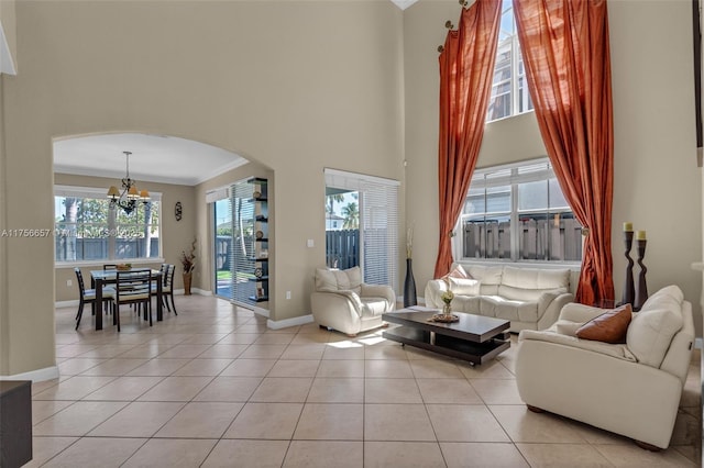 15509 SW 139th Ct, Miami, FL 33177 - living area featuring a chandelier, arched walkways, ornamental molding, a towering ceiling, and light tile patterned flooring