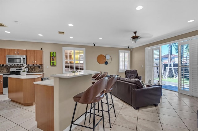 kitchen with visible vents, a kitchen island, light countertops, light tile patterned floors, and stainless steel appliances