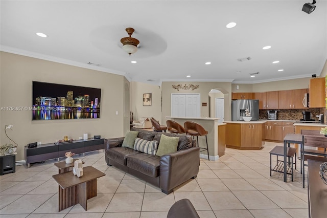 living room featuring light tile patterned floors, visible vents, recessed lighting, and crown molding