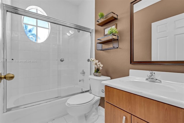 bathroom with toilet, tile patterned flooring, bath / shower combo with glass door, vanity, and a textured wall