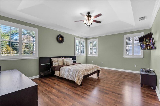 bedroom featuring visible vents, multiple windows, and a tray ceiling