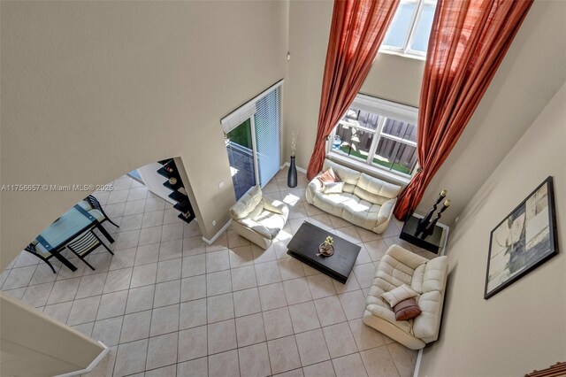 living room featuring tile patterned floors, baseboards, and a healthy amount of sunlight