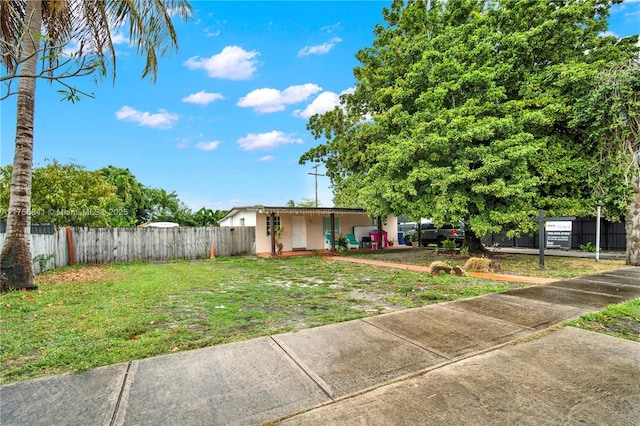 view of front of house with a front lawn and fence