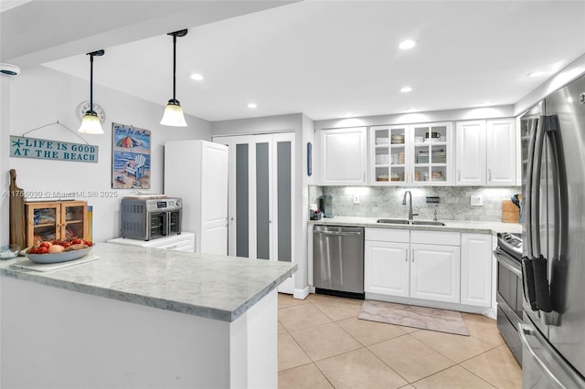 kitchen featuring stainless steel appliances, tasteful backsplash, a sink, and white cabinets