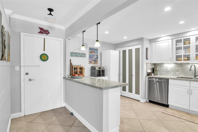 kitchen featuring light tile patterned floors, a sink, white cabinets, stainless steel dishwasher, and tasteful backsplash