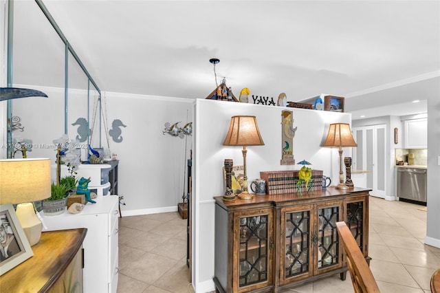 interior space with light tile patterned floors, baseboards, washer / dryer, and crown molding