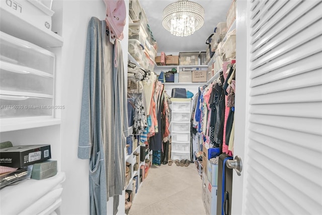 walk in closet featuring an inviting chandelier and tile patterned floors