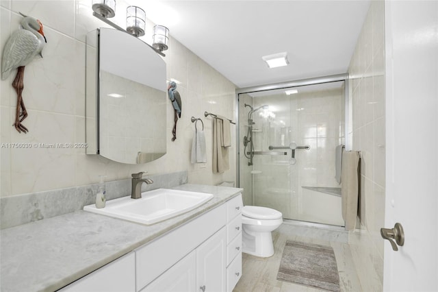 full bath featuring toilet, a shower stall, and tile walls