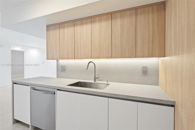 kitchen featuring a sink, light countertops, dishwasher, light brown cabinetry, and modern cabinets