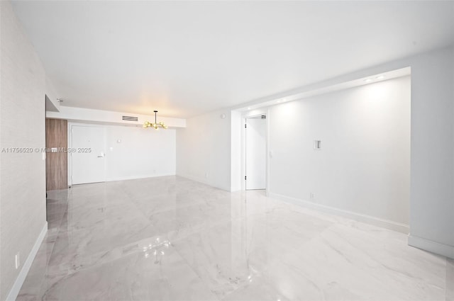 spare room featuring baseboards, marble finish floor, visible vents, and a notable chandelier