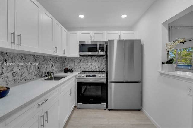 kitchen featuring a sink, white cabinetry, light countertops, appliances with stainless steel finishes, and tasteful backsplash