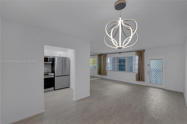 unfurnished living room featuring light wood finished floors and a notable chandelier