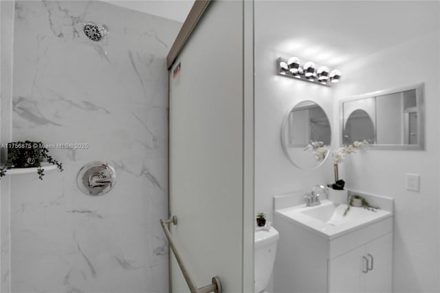 full bathroom featuring a marble finish shower, vanity, and toilet