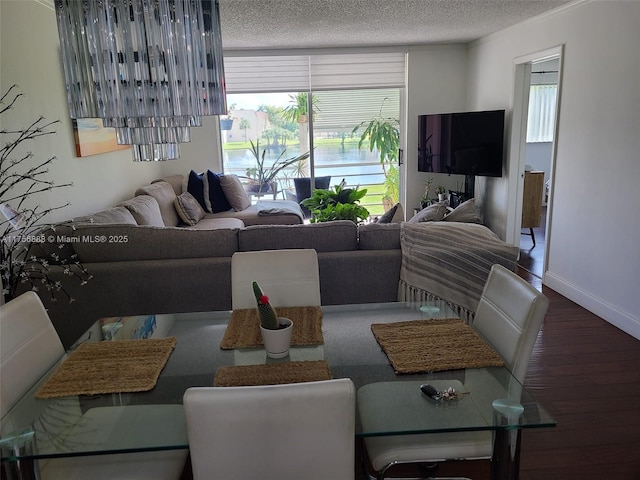 living room featuring plenty of natural light, baseboards, a textured ceiling, and wood finished floors