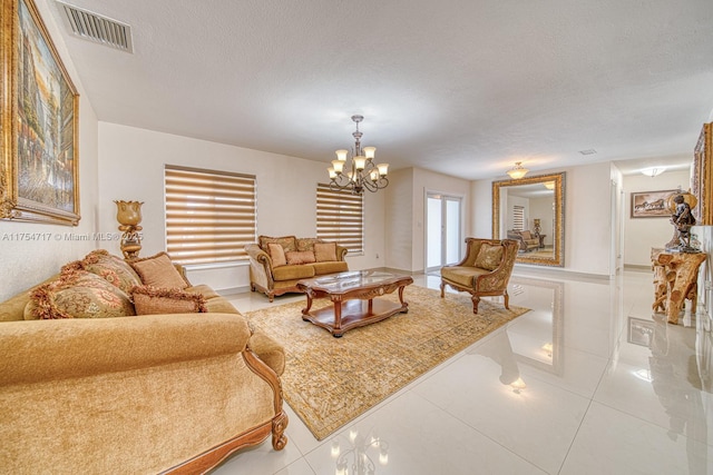 living area with light tile patterned floors, a notable chandelier, visible vents, and a textured ceiling