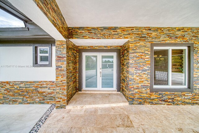 property entrance featuring french doors and stone siding