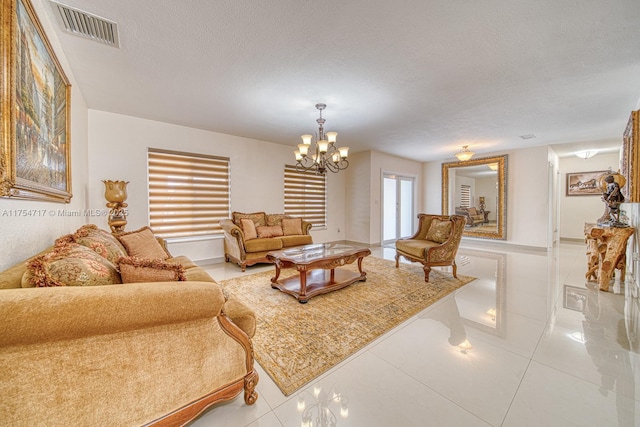 living area with a notable chandelier, light tile patterned floors, visible vents, and a textured ceiling