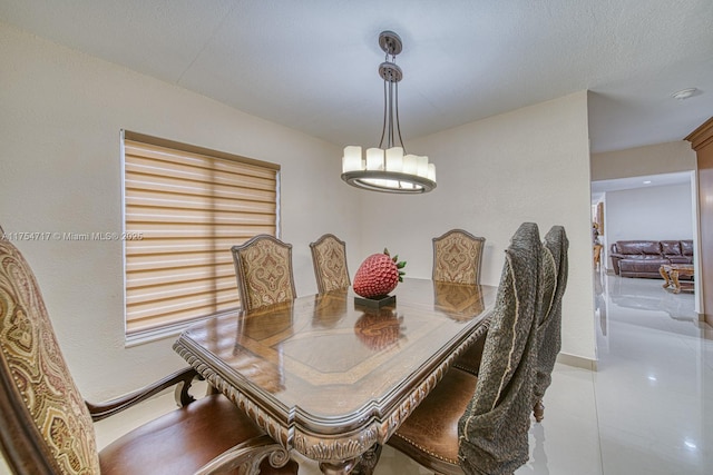 dining room featuring an inviting chandelier, baseboards, and a textured ceiling