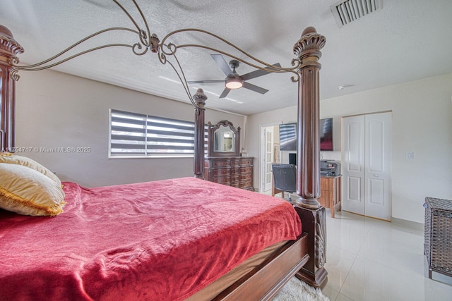 bedroom featuring a ceiling fan, visible vents, and a textured ceiling