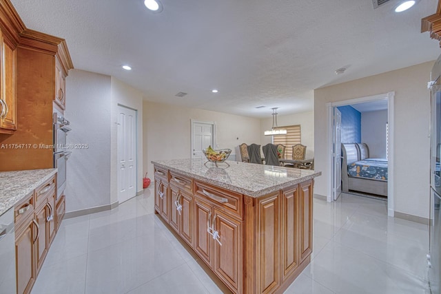 kitchen featuring light tile patterned floors, recessed lighting, a center island, light stone counters, and brown cabinets