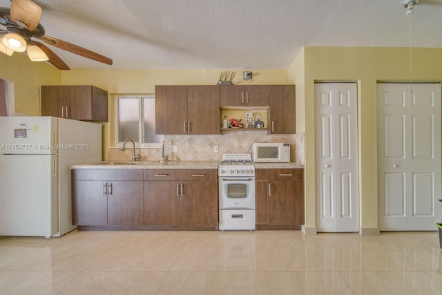 kitchen featuring a sink, light countertops, ceiling fan, white appliances, and decorative backsplash