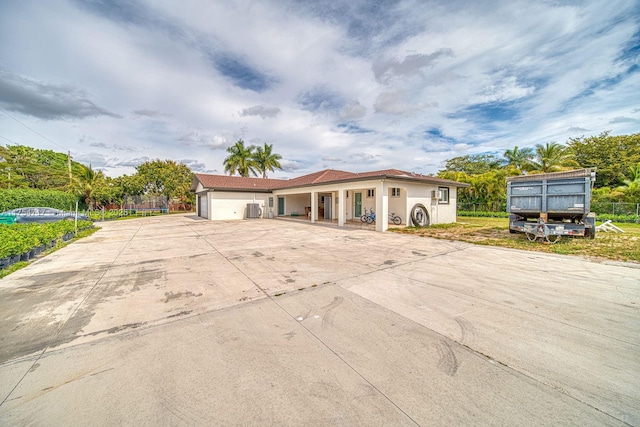 view of front facade with an attached garage, fence, and concrete driveway