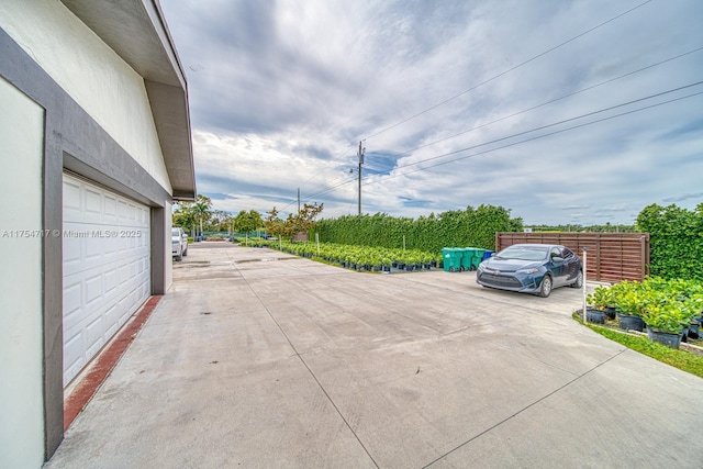 view of vehicle parking with a garage and concrete driveway