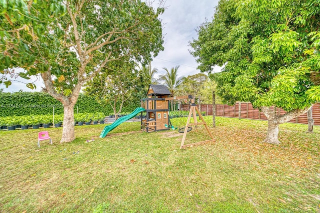 view of playground featuring a yard and fence