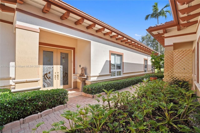 property entrance with french doors and stucco siding