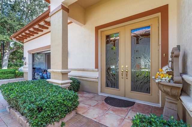 entrance to property featuring french doors and stucco siding