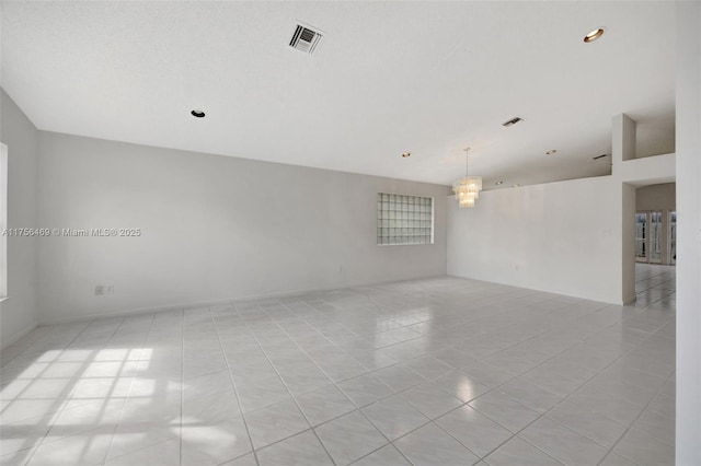 spare room with light tile patterned floors, a chandelier, and visible vents