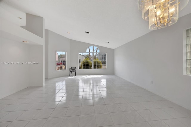 spare room with high vaulted ceiling, visible vents, an inviting chandelier, and light tile patterned floors