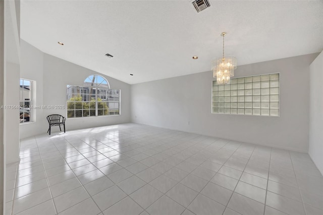 spare room featuring light tile patterned floors, visible vents, lofted ceiling, a textured ceiling, and a notable chandelier