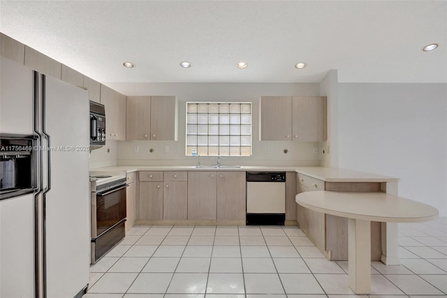 kitchen featuring white appliances, a peninsula, and light brown cabinetry