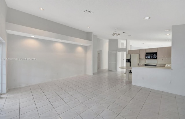 empty room with light tile patterned flooring, visible vents, vaulted ceiling, and recessed lighting