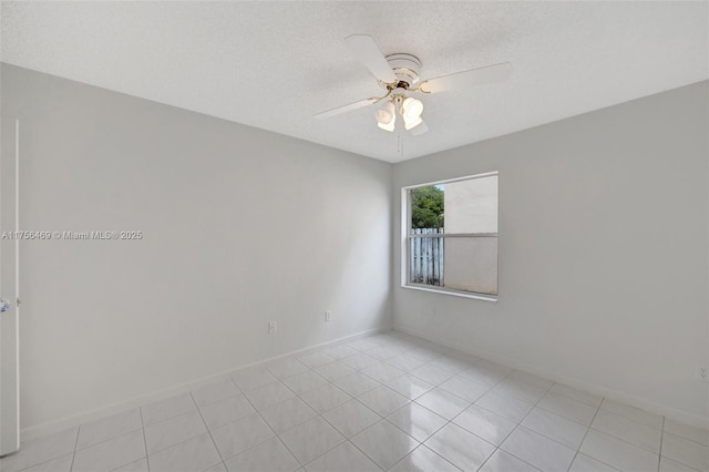 unfurnished room featuring ceiling fan, baseboards, and a textured ceiling